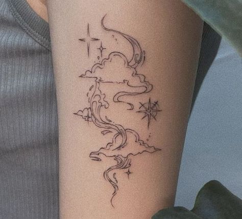 a woman's arm with a tattoo on it that has clouds and stars in the sky