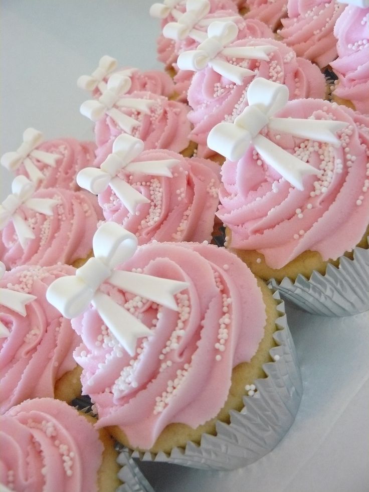 cupcakes with pink frosting and white decorations