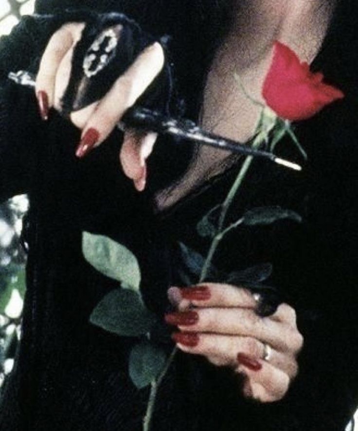 a woman holding a rose and scissors in her hands