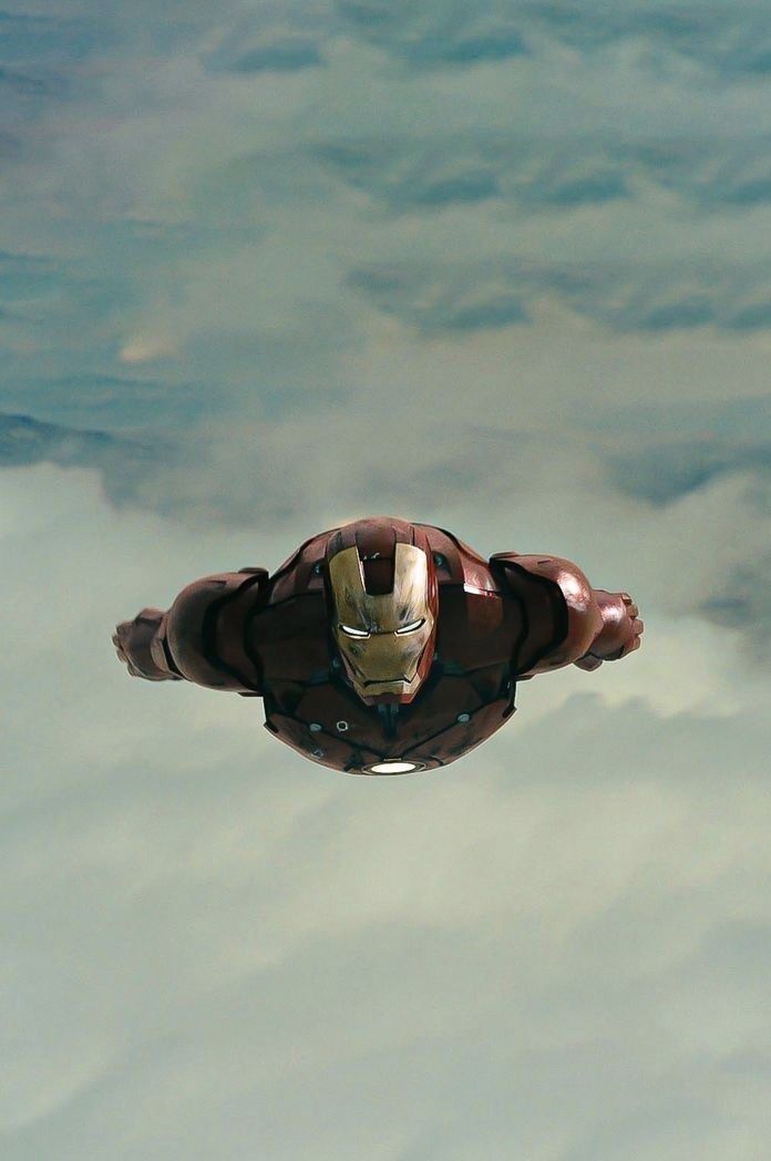 an iron man flying through the sky above clouds