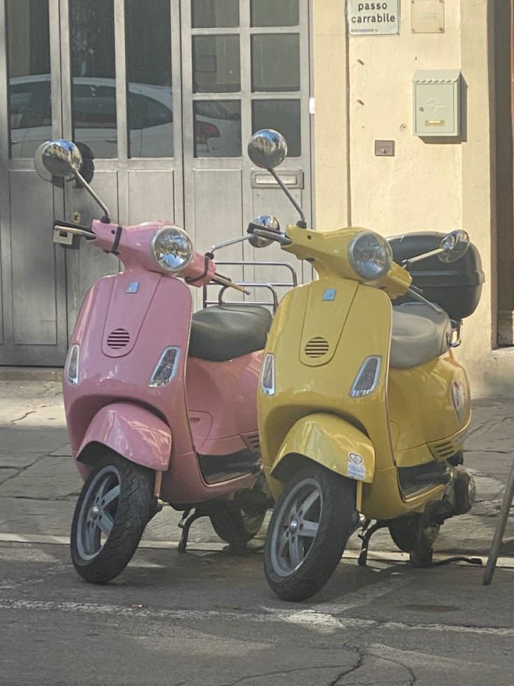 two mopeds are parked on the side of the road in front of a building