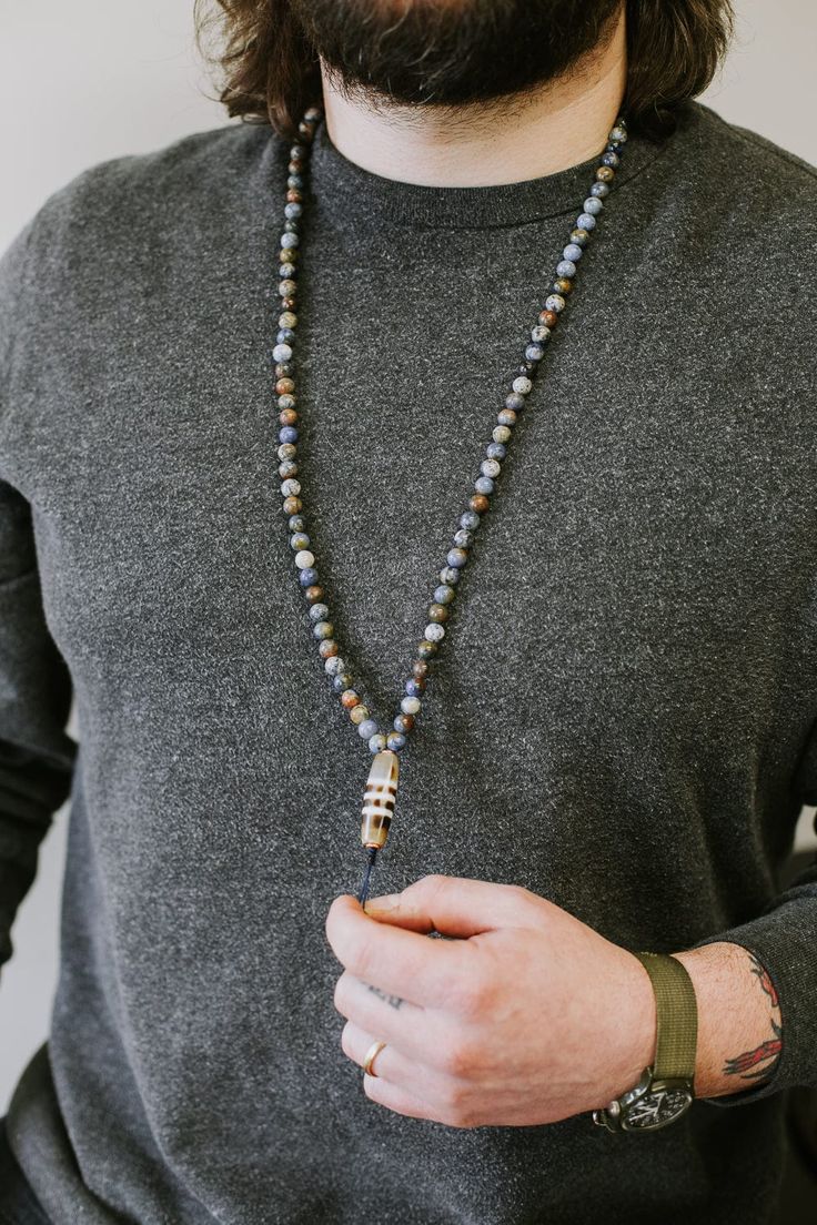 A DharmaShop exclusive design, this 108 bead mala necklace features stunning sunset dumortierite beads with a true agate striped Dzi bead centerpiece. The Dzi bead comes directly from DharmaShop founder, Sander Cohen's personal collection that has accumulated over the last 20 years throughout his travels to Kathmandu and Taiwan. We absolutely love the earthy color tones of the dumortierite beads. The palette reminds us of a fall sunset turning into dusk over Lake Superior. Pairs perfectly with o Sander Cohen, Bohemian Style Men, Fall Sunset, Stunning Sunset, The Third Eye, Adjustable Knot, 108 Mala Beads, 108 Bead, Mala Bracelet