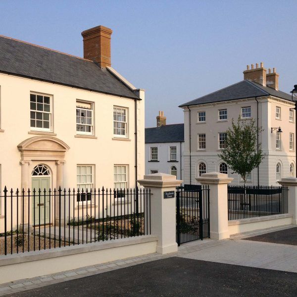 two large white houses with black iron fences