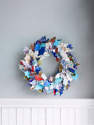 a wreath made out of many different types of paper stars on a gray background with white space in the middle