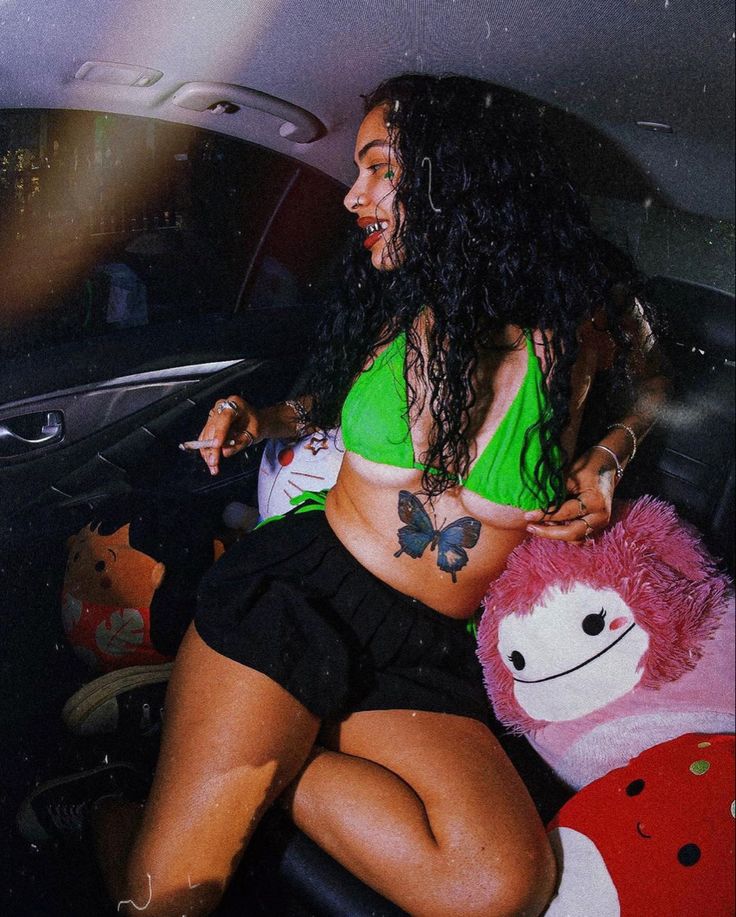 a woman sitting in the back seat of a car next to a stuffed animal bear