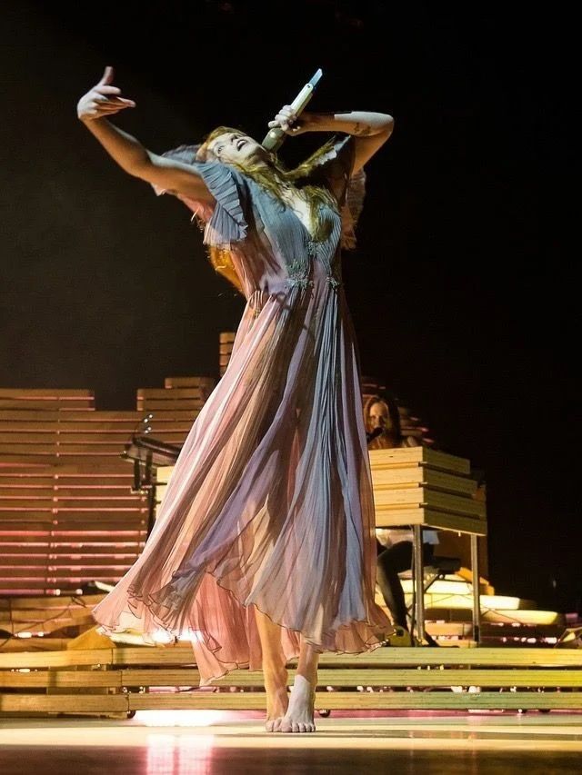 a woman in a dress is dancing on stage