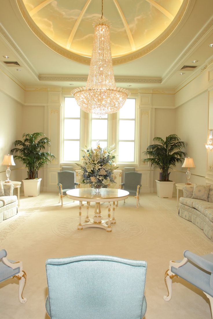 a living room filled with furniture and a chandelier hanging from it's ceiling