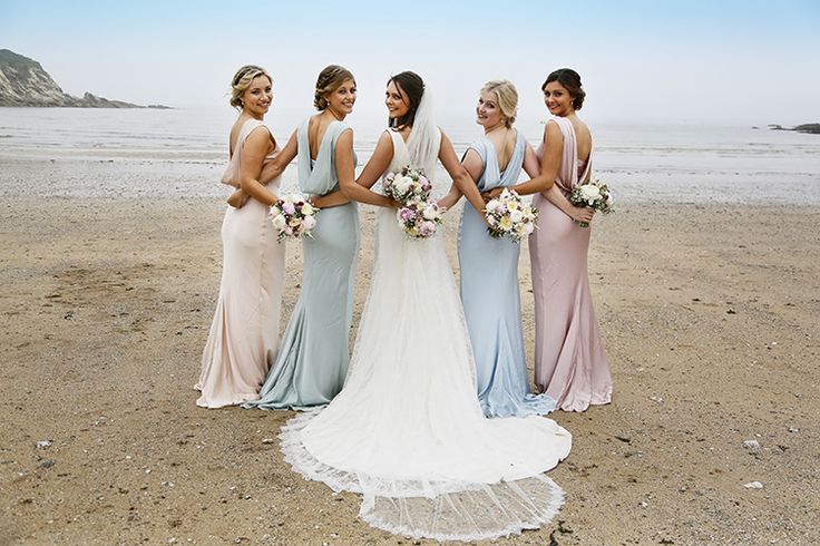 a group of women standing next to each other on a beach