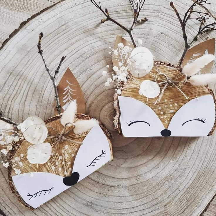 two paper foxes are sitting next to each other on a piece of wood with branches