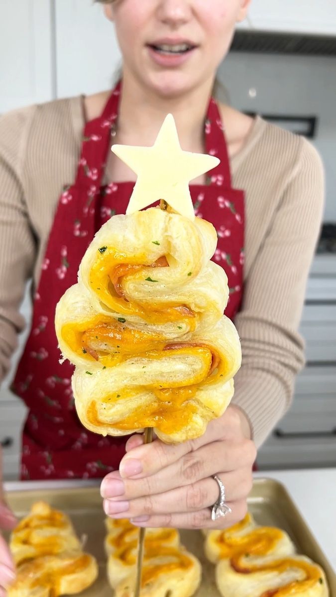 a woman holding up a stack of pretzels in front of her face with a star on top