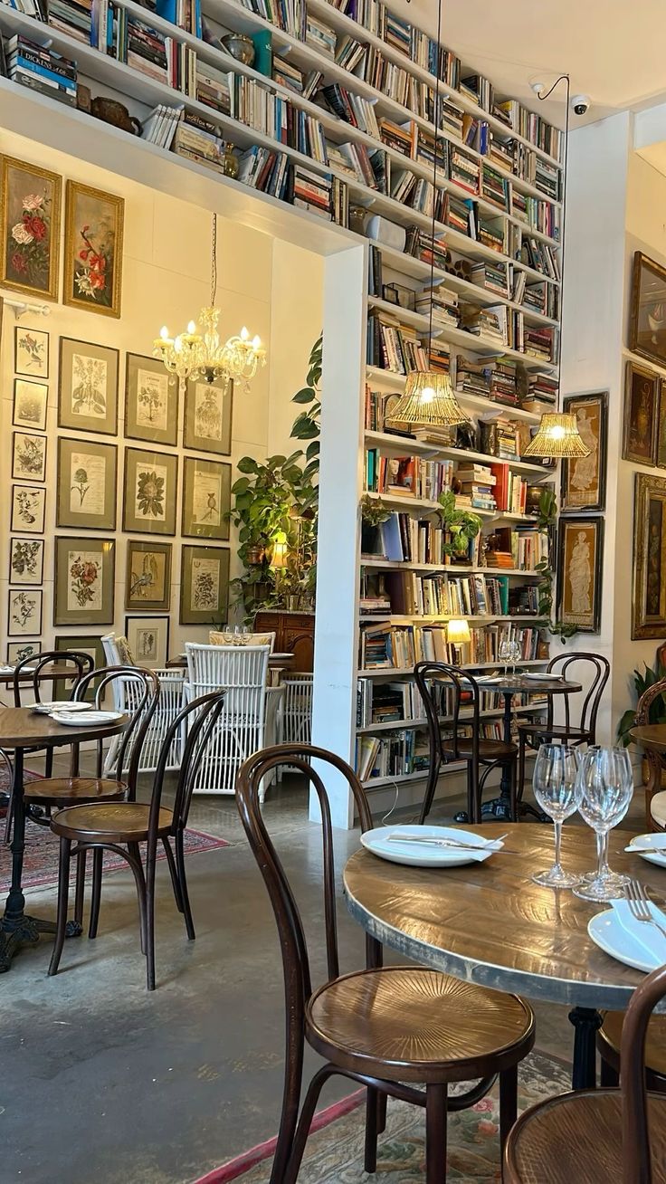 an empty restaurant with tables and chairs in front of a book shelf filled with books