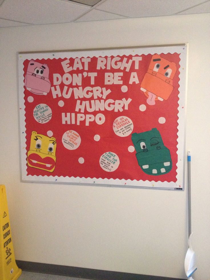 a bulletin board is hanging on the wall in an office with cartoon characters and words