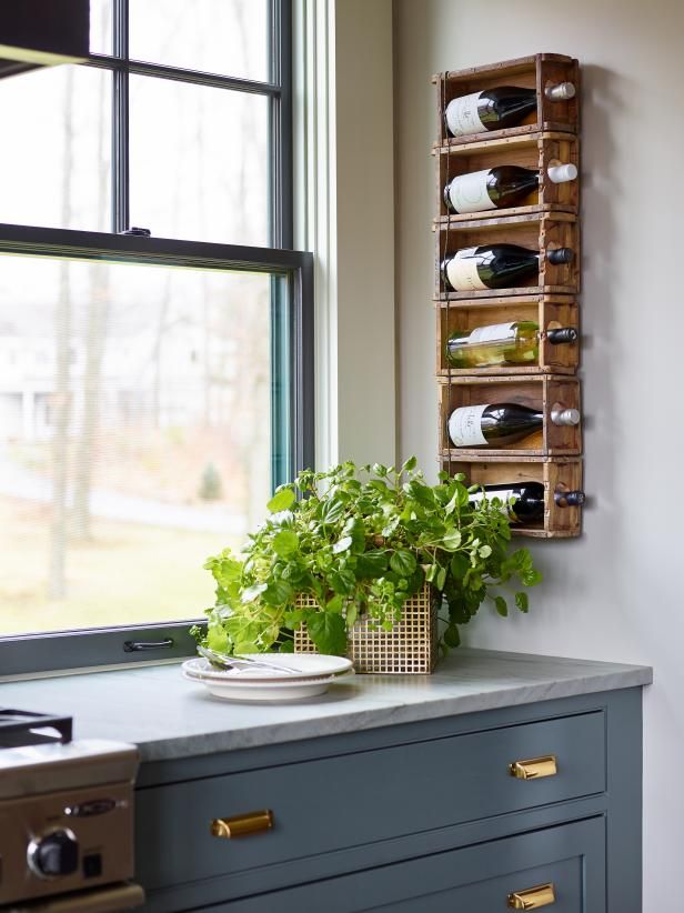 a kitchen counter with wine bottles on it and a plant in front of the window