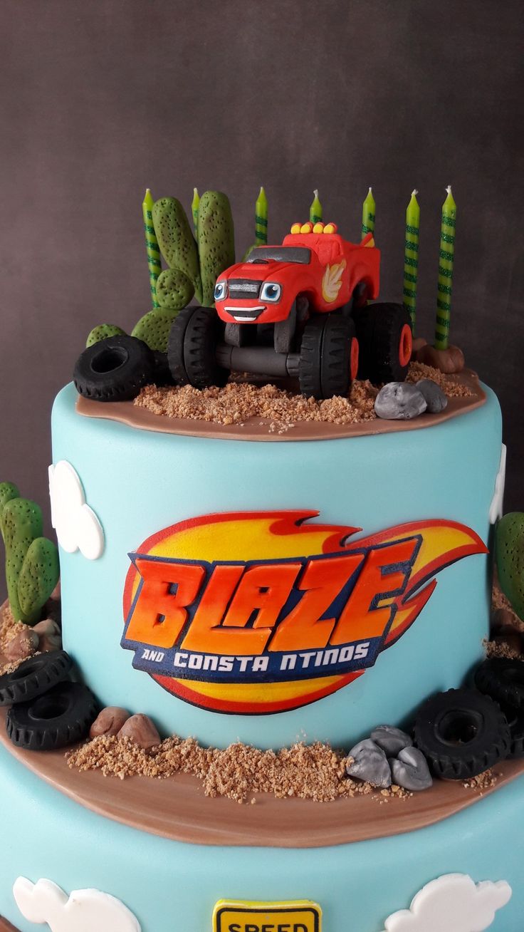 a birthday cake with a monster truck and cactus in the desert on it's side