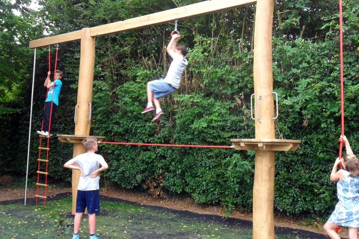 three children are playing on a wooden play set