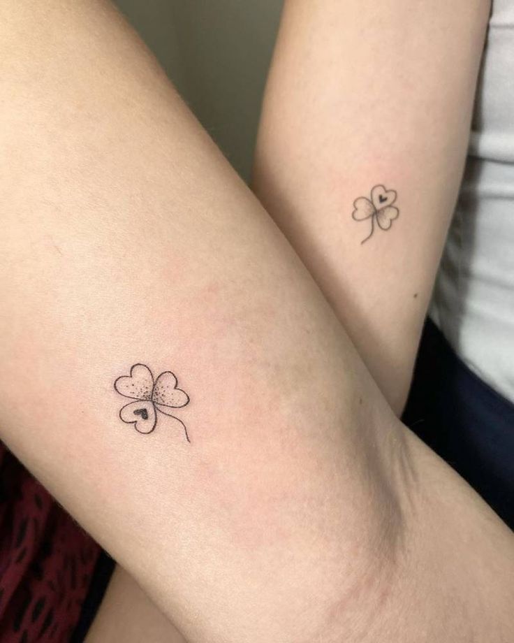 two tattoos on the legs of women with four leaf clovers tattooed on their thighs