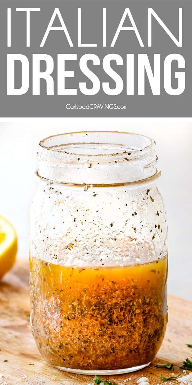 a jar filled with italian dressing sitting on top of a cutting board next to lemons