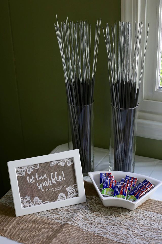 there are two vases with sticks in them on the table next to a sign