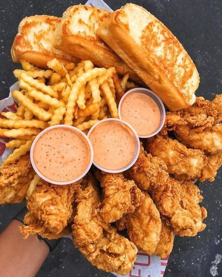 fried chicken, french fries and dipping sauces on a plate