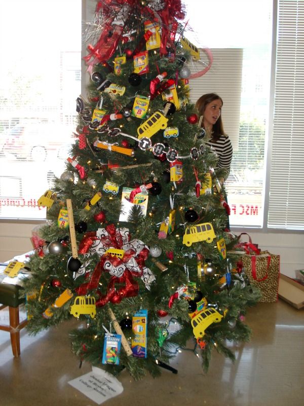 a christmas tree decorated with fire trucks and other toys is shown in front of a window