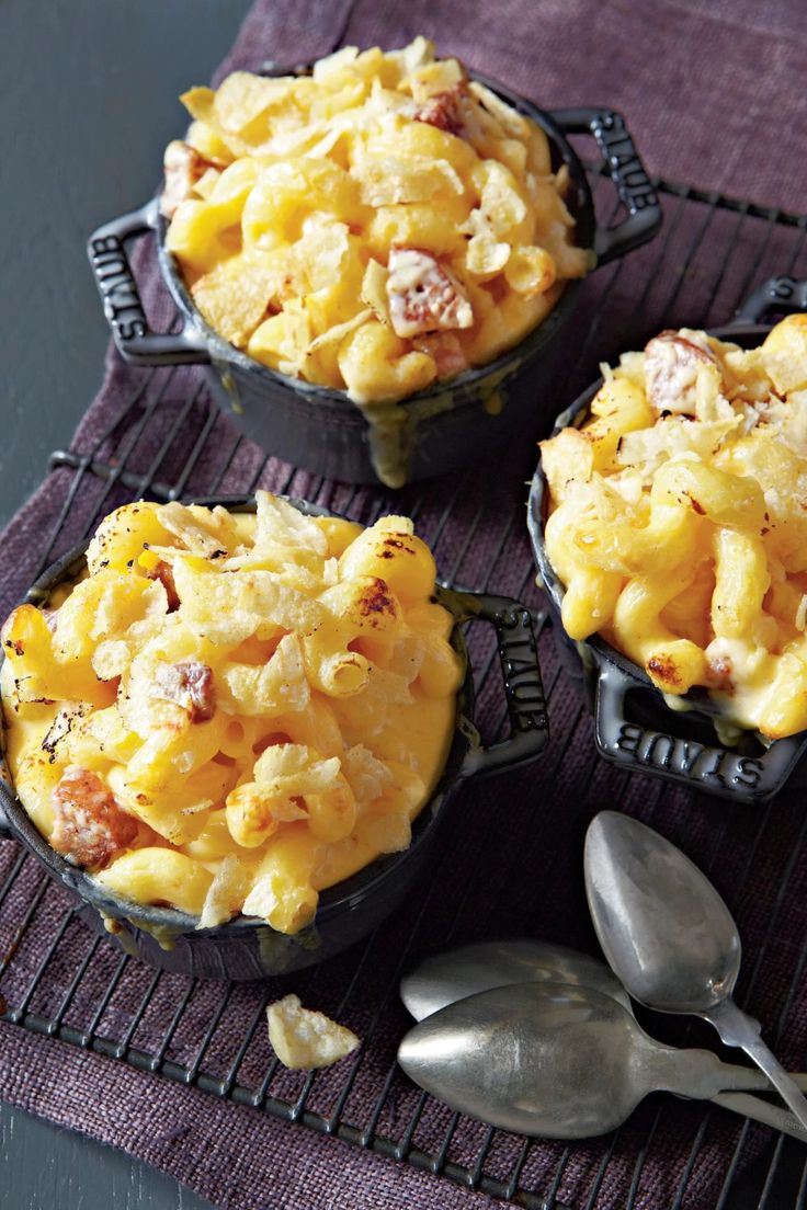 three small dishes filled with macaroni and cheese on top of a purple towel