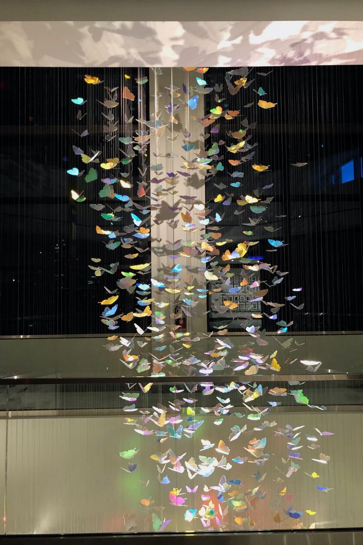 a sculpture with many colorful butterflies hanging from it's sides