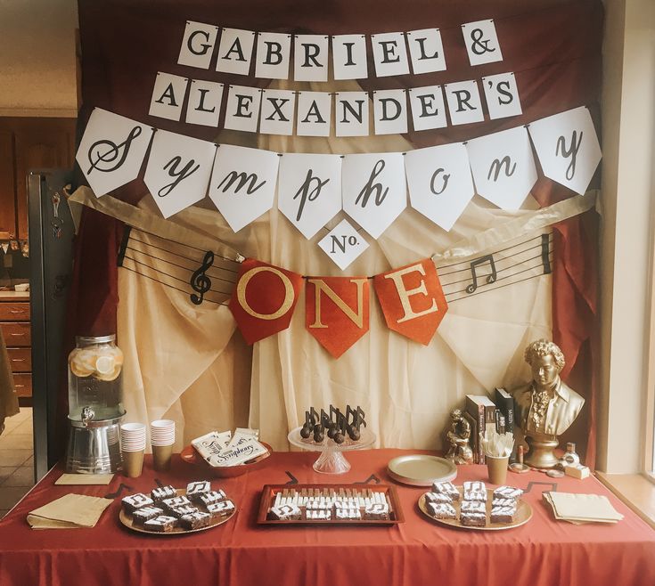 a red table topped with lots of food and desserts next to a sign that says gabril & alexandriars on it