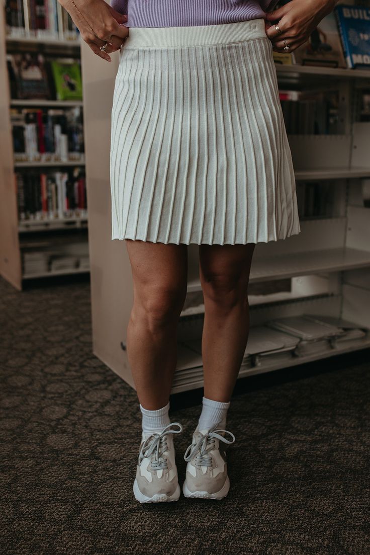 Get ready to turn heads with THE LORALI PLEATED MINI SKIRT IN CREAM. The pleated design adds a touch of sophistication while the knit fabric keeps it cozy and perfect for the fall season. This cute skirt will elevate any outfit and make you stand out from the crowd. Paired with THE SAYDIE SLEEVELESS TOP IN LAVENDER STRIPE & THE GRAYSON SNEAKERS IN NEUTRAL Mini length Pleated Elastic waist 55% cotton, 45% acrylic Runs true to size. Small (0-4), Medium (4-8), Large (8-12). In-seams: Small: 16", Medium: 16.5", Large: 17" Model is 5'5" wearing a small. To view our return policy, click here! Check out our try on video below! Fall Pleated Hem Relaxed Mini Skirt, Fall Mini Skirt With Pleated Hem, Trendy Pleated Tennis Skirt For Fall, Pleated Mini Length Tennis Skirt For Fall, Casual Tennis Skirt With Accordion Pleats And Relaxed Fit, Casual Mini Bottoms With Accordion Pleats, Casual Bottoms With Accordion Pleats, Mini Length, White Skort For Fall, White Knit Skirt For Fall