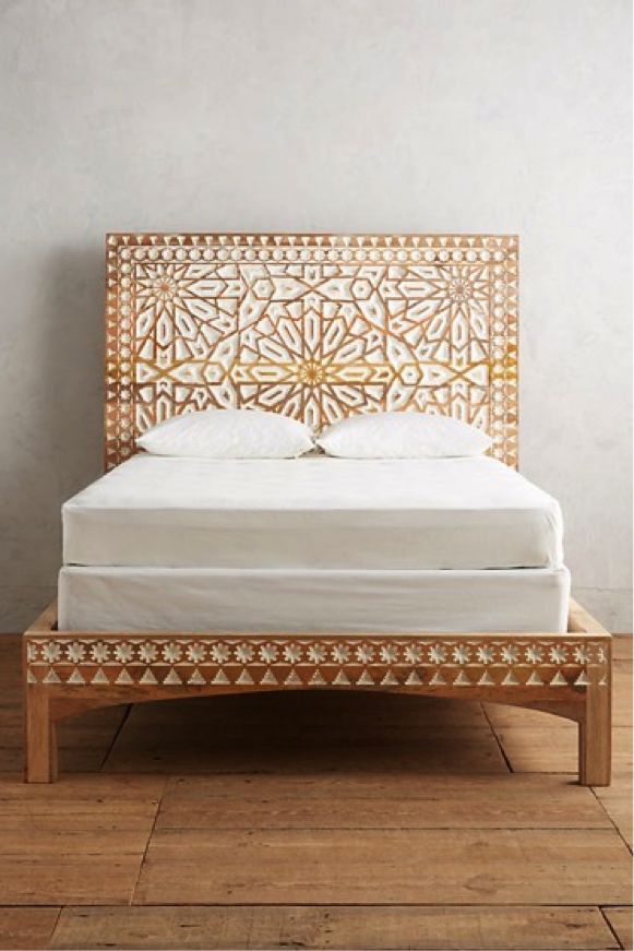 a bed with an intricate wooden headboard and foot board