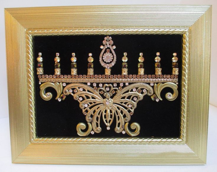 a gold and black framed art piece with candles in the shape of an ornate design