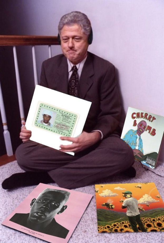 a man sitting on the floor holding up some papers with pictures in front of him