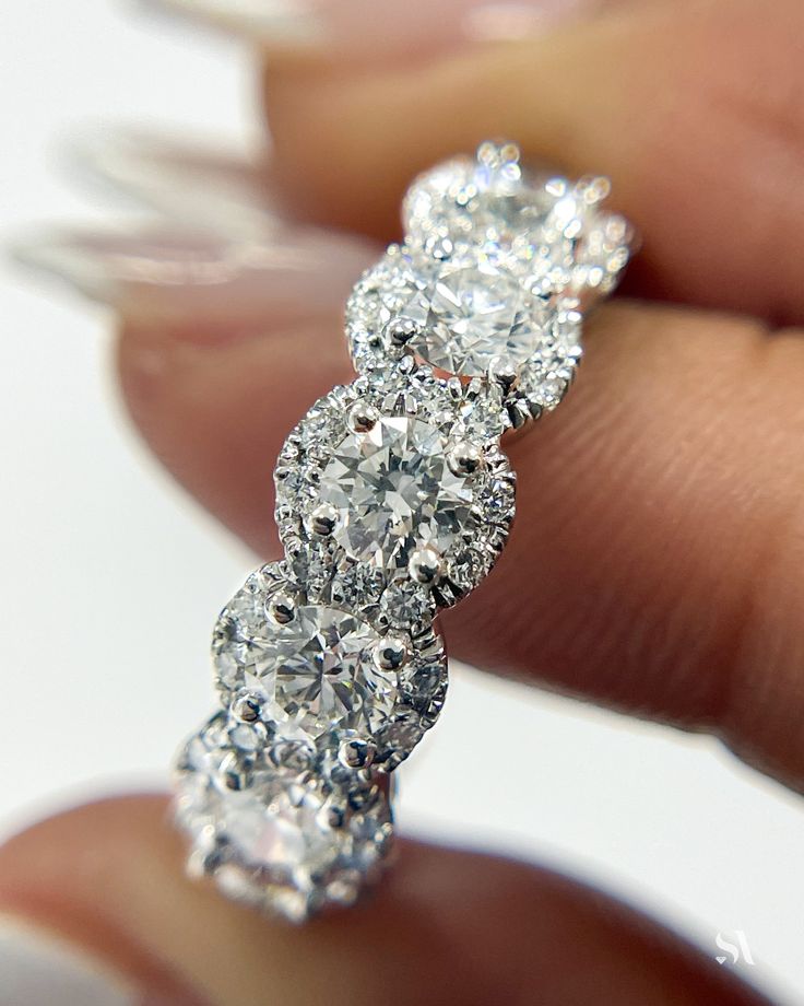 a diamond ring is being held by someone's hand