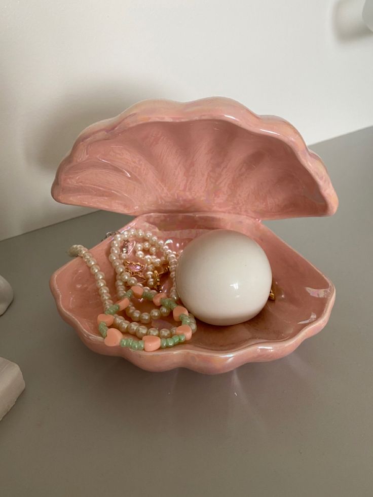 an egg in a pink shell with pearls