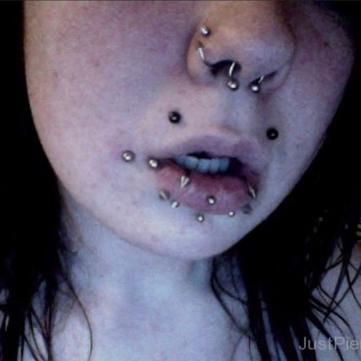 a woman with piercings on her face and nose