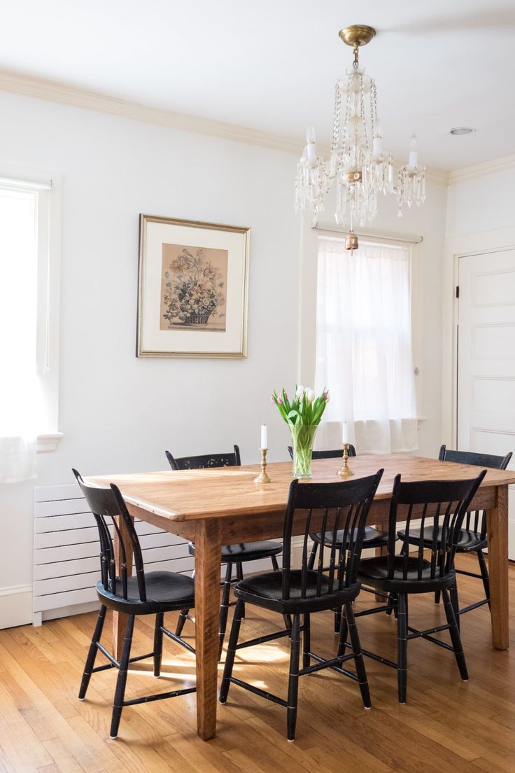 a dining room table with black chairs and a chandelier