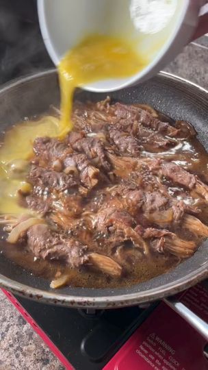 someone is pouring sauce on some meat in a skillet that's sitting on top of a stove