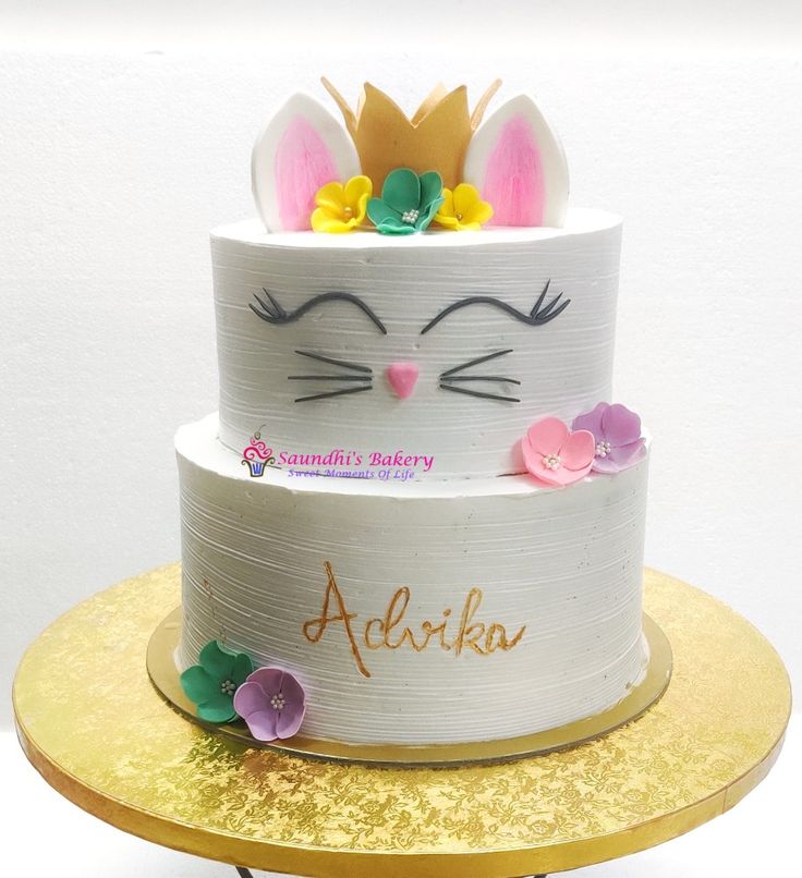 a three tiered cake decorated with flowers and bunny ears