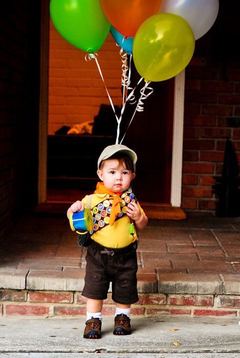 a little boy holding onto some balloons