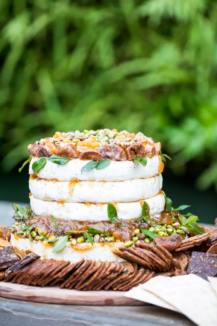 a close up of a cake on a plate with crackers and leaves around it