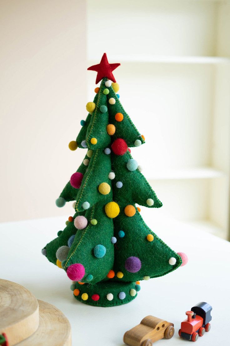 a small green christmas tree sitting on top of a table