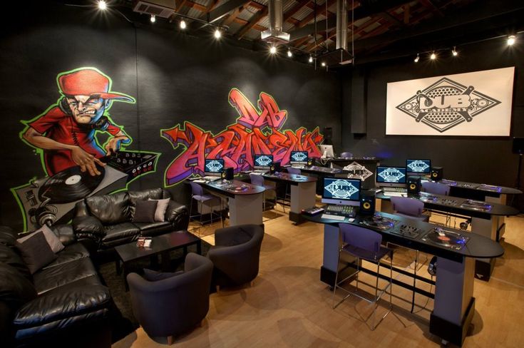 a room filled with lots of black furniture and walls covered in graffiti art on the wall