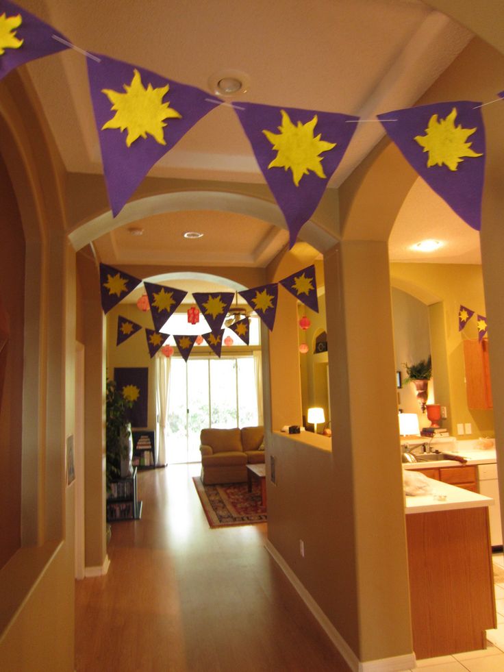 a hallway decorated with purple and yellow buntings, stars and decorations on the ceiling