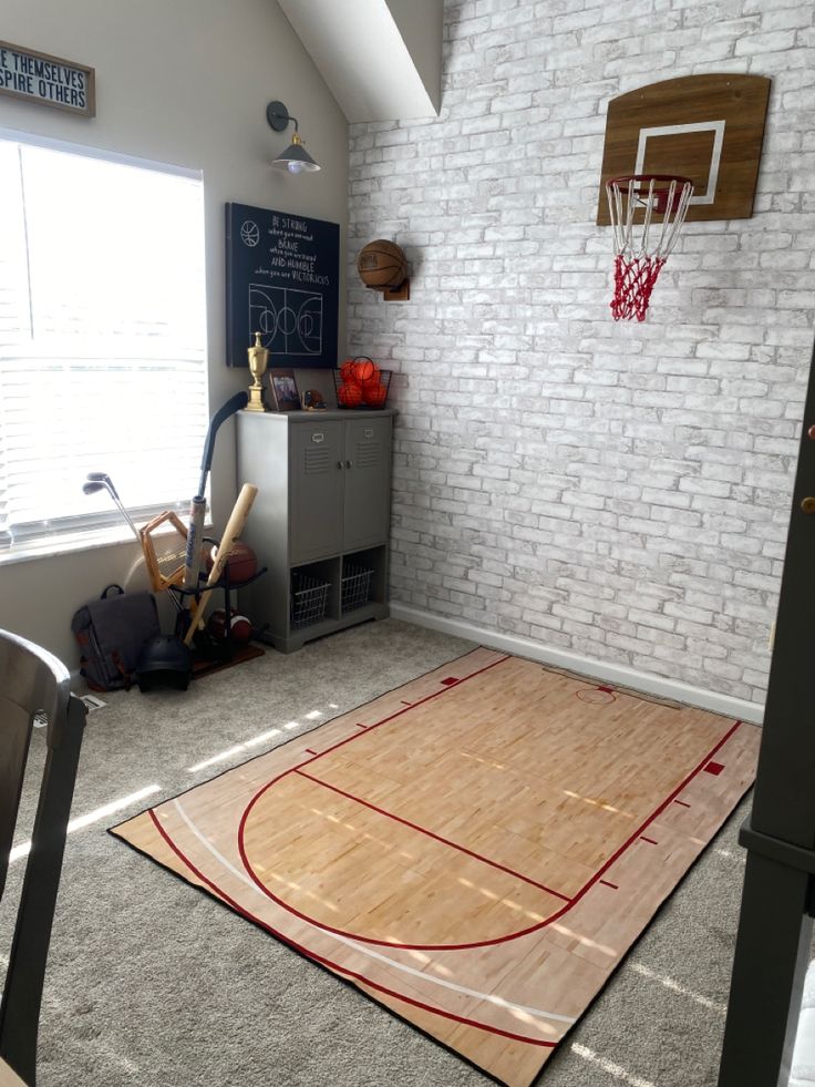 an indoor basketball court is in the corner of a room with white brick walls and gray carpet