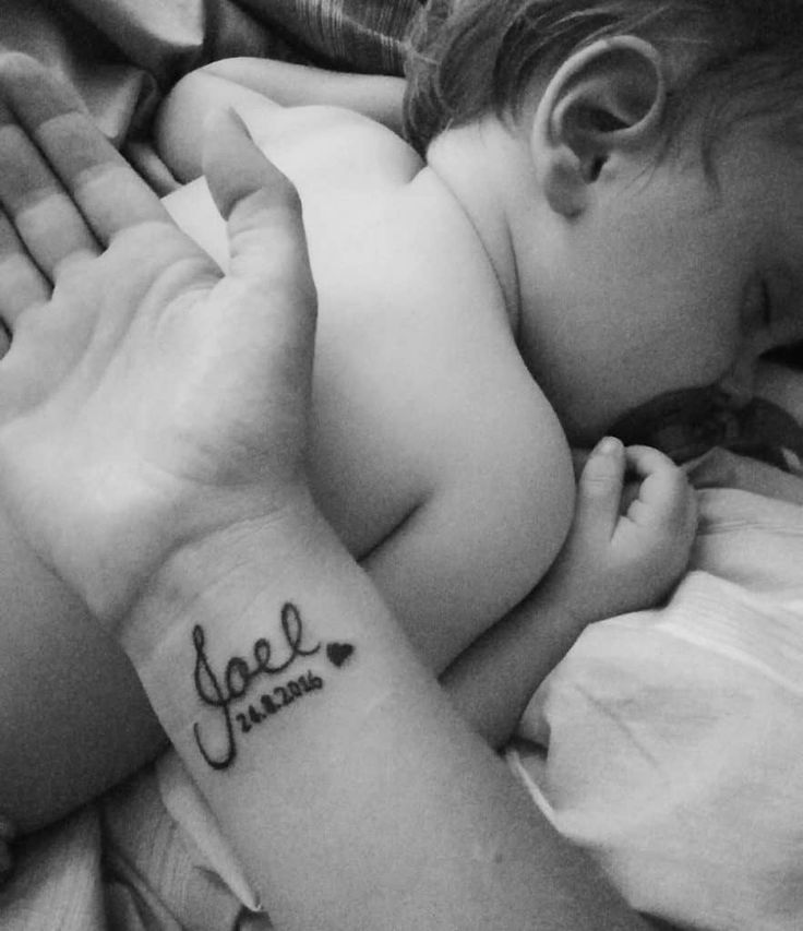 a woman holding a small child with a tattoo on her arm that says, love