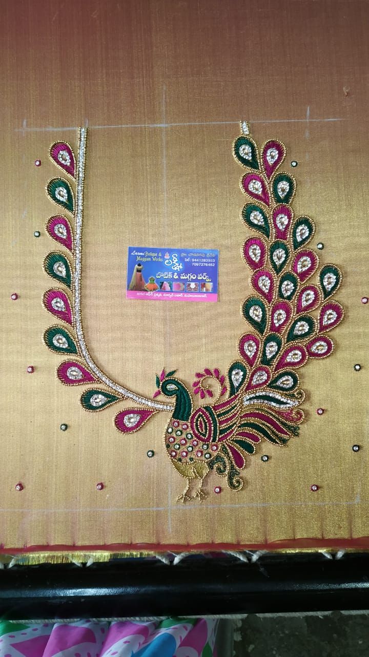 an embroidered peacock on a piece of cloth