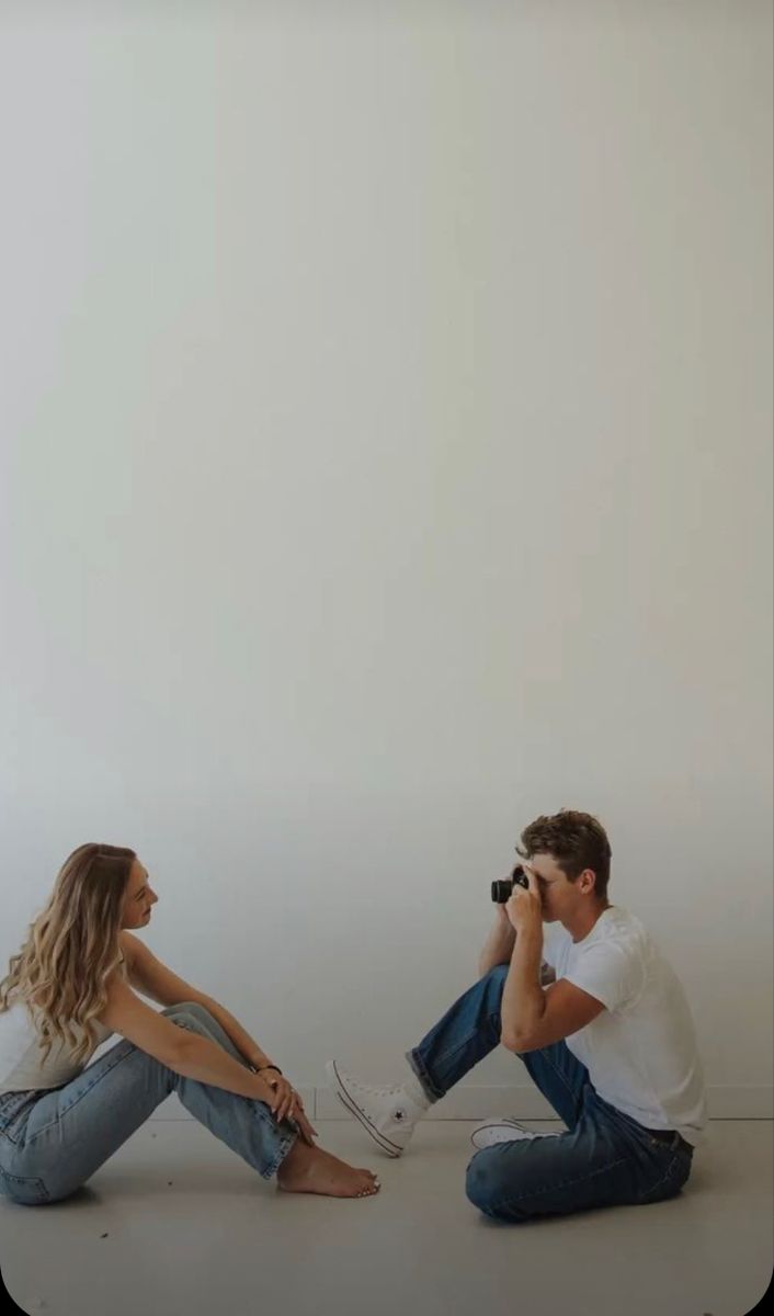 a man and woman sitting on the floor talking