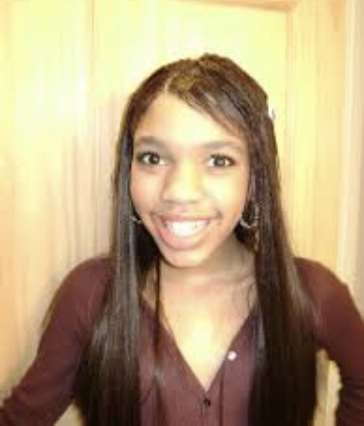 a girl with long hair smiling for the camera