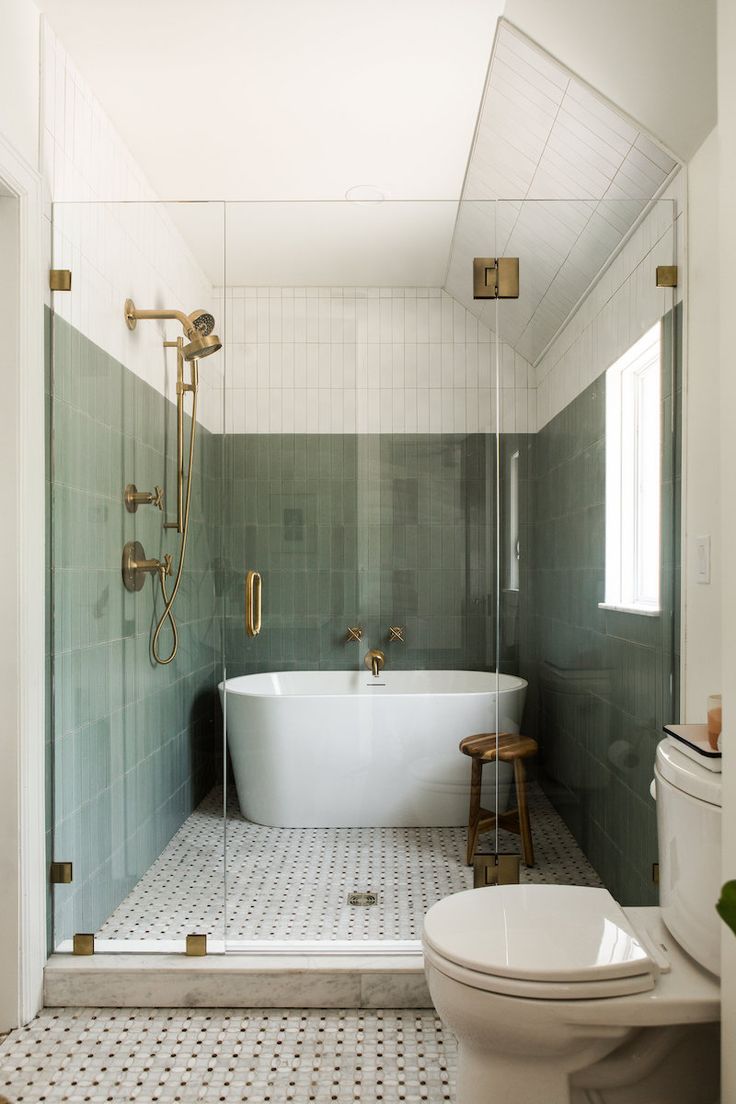 a bath room with a toilet a tub and a shower head mounted to the wall