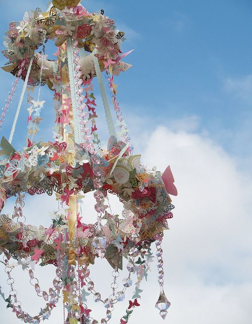 a chandelier hanging from the ceiling in front of a blue sky with clouds