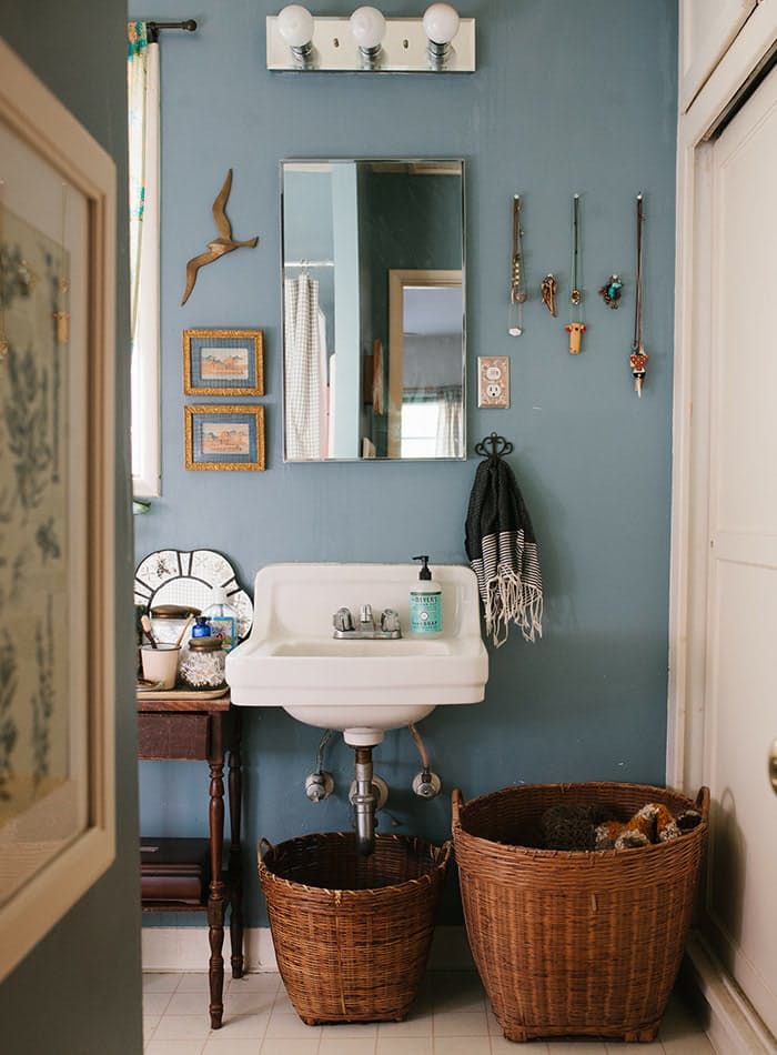 a bathroom with two baskets on the floor and a sink in the corner next to it